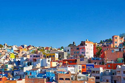 Bunte Häuser einer mexikanischen Stadt und blauem Himmel. 