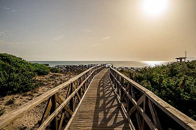 Sonnenuntergang über einen Steg am Strand. 