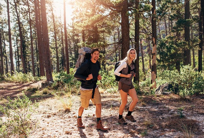 Hotel Hochsauerland 2010 - 490684_AdobeStock_177405388_Hiking-couple-walking-in-forest-wearing-backpacks